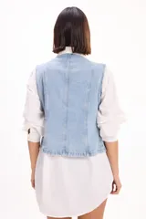 Chaleco de denim color azul claro, sin mangas, con diseño estilo militar decorado con doble botonadura metálica frontal.