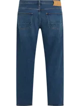 Jeans Tommy Hilfiger modelo Tapered Moore de corte recto y tiro medio, en color azul con lavado Nori Indigo. Confeccionados en mezcla de algodón y cáñamo, cuentan con diseño clásico de cinco bolsillos, cierre de botón y cremallera.