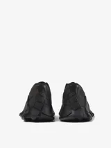 Zapatillas negras con malla Sorona, empeines de HyphaLite y MIRUM, cordones de TENCEL Lyocell, plantillas OrthoLite Recycled, entresuelas de EVA de caña de azúcar y suelas de goma.