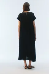 Vestido midi evasé color azul, confeccionado en lino, con escote redondo, mangas cortas con dobladillo vuelto y bolsillos laterales. Presenta un ruedo asimétrico, más largo en los laterales.