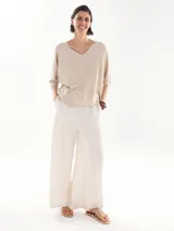 Remera de lurex color beige con escote en V y mangas cortas.