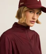 Campera rompevientos deportiva de mujer, marca Get Over, color beige con sutiles rayas verticales, cuello alto, cierre frontal con cremallera y puños ajustados.