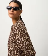 Blusa de viscolino con estampado animal print de leopardo, cuello redondo, mangas largas abullonadas y cierre frontal oculto.