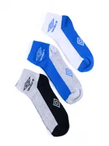 Pack de tres pares de medias deportivas cortas Umbro, confeccionadas en algodón con refuerzo de felpa (terry). Incluyen un par en combinación blanca y azul, un par en azul y gris, y un par en gris y negro, todas con el logo y nombre de la marca estampado en el lateral.