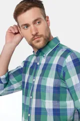 Camisa de manga larga con diseño de cuadros en tonos de verde, azul y blanco, con cuello abotonado y cierre frontal de botones.