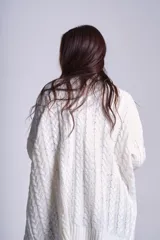 Cárdigan negro tejido con diseño de ochos, corte holgado y bolsillos frontales.