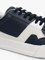 Zapatillas de tenis Tommy Hilfiger de corte bajo, confeccionadas en piel napa color azul marino con paneles laterales en contraste color blanco. Presentan cierre con cordones, suela de goma blanca y logo de la marca grabado en el lateral y el talón.