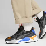 Championes Puma modelo RS-X Geek de diseño retro-futurista, con exterior de mesh y capas superpuestas de PU, en color negro con detalles en naranja, azul y gris.