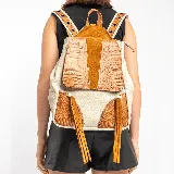 Mochila de cuero vacuno color arena y tostado, con dos bolsillos externos y un bolsillo en la tapa trasera. Interior forrado con bolsillo con cierre y bolsillo para el móvil.