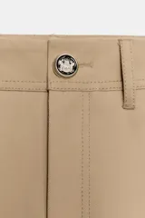 Pantalón de sarga en color beige, con tiro medio, cintura con trabillas y pernera recta. Presenta bolsillos de vivo en el delantero, cierre frontal con cremallera y botón metálico.
