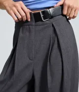 Pantalón sastre de corte barrel, color gris oscuro, con cintura alta, pinzas delanteras y diseño de pierna ancha.