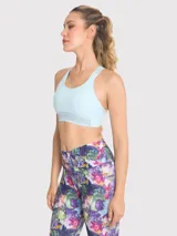 Top deportivo celeste con soporte medio, almohadillas removibles, tirantes anchos y espalda deportiva. Presenta detalles de encaje en la banda inferior y en los tirantes.