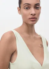 Vestido largo de viscosa en color verde menta, con diseño evasé, escote en pico y tirantes anchos. Presenta un delicado detalle de encaje en la zona del torso y cierre de cremallera en la parte posterior.