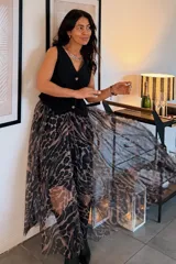 Falda larga de corte evasé con estampado animal print en tonos oscuros y grises, confeccionada en tejido translúcido.