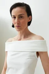 Remera de color marrón con escote bardot, diseño ajustado al cuerpo y mangas cortas.