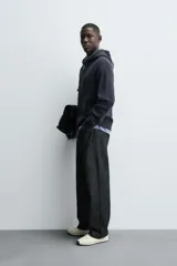 Sudadera hoodie relaxed fit color azul marino, confeccionada en tejido waffle con estructura cuadrillé. Cuenta con capucha ajustable, manga larga, bolsillos delanteros tipo canguro, acabados en rib y cierre frontal de cremallera. Presenta un efecto lavado.