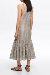 Vestido midi con estampado de cuadros vichy en tonos beige y azul, escote en V, tirantes finos ajustables con lazos en los hombros y volante fruncido en el bajo.