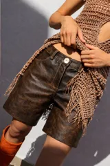 Bermuda de cuero color marrón oscuro con efecto desgastado, tiro medio, cierre frontal con botón y bolsillos.