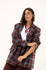 Blazer de corte oversize con estampado de cuadros en tonos azul, bordó y marrón. Presenta solapas clásicas, bolsillos con solapa en el frente y cierre frontal con botones.