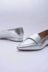 Mocasines negros de cuero con punta fina y detalle de antifaz.