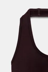 Body de cuello halter confeccionado en tejido rib, con diseño de espalda descubierta y cierre inferior.