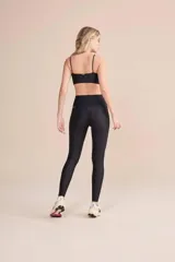 Calza deportiva de tiro alto con diseño de alta compresión y textura acanalada con leve brillo. Cuenta con un bolsillo trasero en la cintura y tecnología de ajuste adaptable.