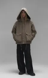 Campera técnica liviana color beige, confeccionada en microfibra de alta densidad con acabado mate. Presenta mangas desmontables que permiten convertirla en chaleco, cuello tipo camisa, cierre frontal oculto bajo cartera y logo bordado en el pecho. Incluye cuatro bolsillos frontales de gran tamaño con solapa y puños con elástico.