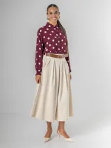 Camisa de manga larga en fibrana color bordó con estampado de lunares grandes en color crema. Presenta cuello camisero y cierre frontal de botones.