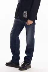 Pantalón de jean azul oscuro de corte recto, con refuerzos en las rodillas y bolsillos laterales. Diseño de estilo cargo con frente reforzado.