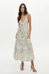Vestido midi de lino y viscosa color crudo con estampa exclusiva multicolor, escote en V, breteles regulables, bolsillos laterales y detalles de vainillas decorativas.