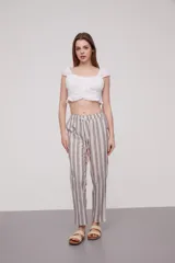 Pantalón babucha celeste con rayas verticales blancas, cintura elástica con cordón y detalle de borlas.