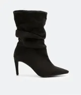 Bota de caña media color negro, con puntera fina, taco alto y textura símil gamuza.