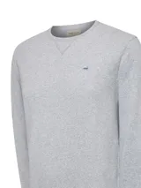 Buzo de algodón orgánico color gris melange, de diseño clásico con cuello redondo, manga larga y terminaciones en rib. Cuenta con un pequeño parche bordado con forma de pato en el pecho.