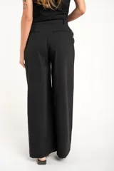 Pantalón negro de vestir, de corte wide leg y tiro medio.