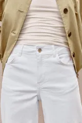 Jeans de tiro alto con diseño wide leg y corte cropped. Presenta cinco bolsillos, cierre frontal con cremallera y botón metálico.