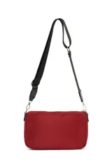 Bandolera pequeña de material sintético color beige claro, con cierre de cremallera frontal y correa ancha ajustable de tela negra.