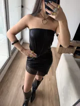 Vestido corto tipo strapless de efecto cuero negro, con detalle de puntilla en el ruedo.