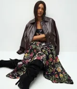 Campera bomber de cuero sintético color marrón oscuro, con cuello camisero, cierre frontal con botones metálicos y elástico en el ruedo.