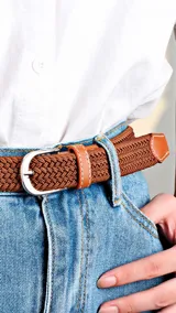 Cinto casual unisex de diseño trenzado elástico en color marrón, con detalles en cuero sintético y hebilla metálica plateada.
