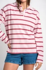 Sweater tipo polo de manga larga con diseño a rayas horizontales en tonos rosado y bordó. Presenta cuello camisero con solapa y cierre frontal parcial.