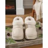 Pantuflas botitas color tostado con diseño acolchado y plataforma, forradas con corderito sintético blanco en el interior y el cuello. Cuentan con una pequeña etiqueta decorativa en el lateral.