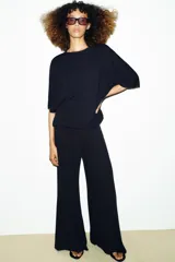 Remera oversize gris melange de tejido fluido, con cuello redondo y mangas cortas amplias.
