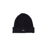 Gorro tipo beanie de punto acanalado en color azul marino, con el logo del cocodrilo característico de la marca bordado en el frente.