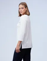 Blusa blanca de tejido elastizado marca Ruby Rd. Tiene escote redondo con aplique metálico y mangas 3/4.
