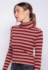 Polera de manga larga con cuello alto, confeccionada en tejido de punto con diseño de rayas horizontales en blanco y negro.