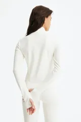 Campera deportiva crop con cuello alto, cierre frontal completo y mangas largas con abertura para el pulgar.