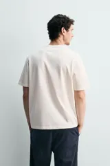 Camiseta de corte relajado confeccionada en algodón, con cuello redondo acabado en rib y manga corta.