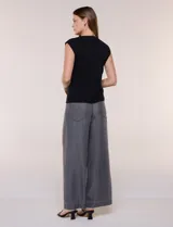 Buzo sin mangas de punto fino color beige, con calce al cuerpo y escote volcado estructurado con solapa superpuesta en el pecho.