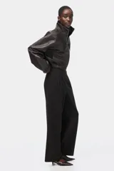 Pantalón de punto de corte holgado y tiro alto con elástico oculto en la cintura, piernas amplias con pinzas y bolsillos al bies.
