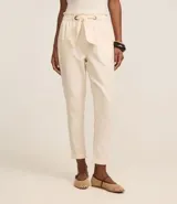 Pantalón carrot de sarga color crudo, con cintura elástica, lazo ajustable y bolsillos laterales.